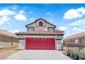 Charming two-story home features a red garage door, a tile roof, and an arched window at 6374 Horizon Ridge Ct, Las Vegas, NV 89156