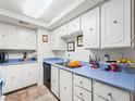 Functional kitchen featuring clean white cabinetry, blue countertops, and essential appliances at 6630 Bubbling Brook Dr # C, Las Vegas, NV 89107