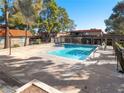 Community pool with refreshing water, surrounded by mature trees providing shade and relaxation at 6630 Bubbling Brook Dr # C, Las Vegas, NV 89107