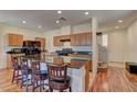 Kitchen featuring a granite countertop island with barstool seating and wood cabinets at 7104 Flathead River Ave, Las Vegas, NV 89179