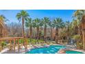Inviting community pool with mature palm trees, tanning deck, and covered seating, a perfect vacation spot at 728 Hardy Way # E, Mesquite, NV 89027