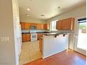 Well-lit kitchen featuring wood cabinets, tile floors, modern appliances, and breakfast bar at 9034 Grenache St, Las Vegas, NV 89148