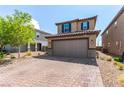 Charming home features a brick driveway, manicured landscaping, and a two-car garage, enhancing its curb appeal at 9690 Langden Brook St, Las Vegas, NV 89178