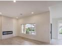 Bright living room with modern fireplace and large windows offering great views at 10421 Linfield Pl, Las Vegas, NV 89134