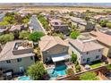 Aerial view of a home with a pool, landscaping, mountain views in the distance at 10474 Palmadora St, Las Vegas, NV 89178