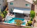 Aerial view of a backyard pool with a covered patio and lounge chairs at 10474 Palmadora St, Las Vegas, NV 89178
