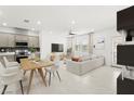 Spacious living area seamlessly connects to the modern kitchen, featuring an island and a comfortable seating arrangement at 1103 Tektite Ave, Henderson, NV 89011