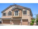 Townhome with a balcony, three garage doors, and a stucco facade at 1554 Ward Frontier Ln, Henderson, NV 89002