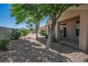 Serene backyard with gravel landscaping, mature trees, and a covered patio area at 2315 Sun Cliffs St, Las Vegas, NV 89134
