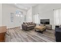 Bright living room features wood floors, soaring ceilings, and large windows that flood the space with natural light at 2717 Cool Lilac Ave, Henderson, NV 89052