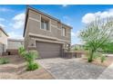Beautiful front exterior featuring a two-car garage, attractive landscaping, and a contemporary design under a bright sky at 311 Lilian Faith Ave, North Las Vegas, NV 89031