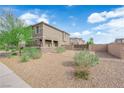 Expansive front yard with desert landscaping, a gated entrance, and a contemporary home design on a sunny day at 311 Lilian Faith Ave, North Las Vegas, NV 89031