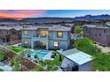 Expansive backyard featuring a sparkling pool, lush landscaping, covered patio, and mountain views at 362 Port Reggio St, Las Vegas, NV 89138
