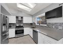 Well-equipped kitchen features stainless steel appliances, grey countertops, backsplash, and a bright window at 3905 Blairmoor St, North Las Vegas, NV 89032