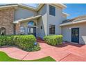 Close-up view of the attractive entrance, lush landscaping and red walkway at 4075 E Oquendo Rd, Las Vegas, NV 89120