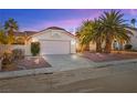 Charming single-story home with a two-car garage, desert landscaping, and mature palm trees at 433 Old Palms Dr, Las Vegas, NV 89123