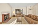Comfortable living room with a brick fireplace, carpet, and a large window at 433 Old Palms Dr, Las Vegas, NV 89123