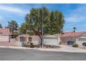 Single story home featuring desert landscaping, mature trees and an attached two-car garage at 6624 Old Oxford Ave, Las Vegas, NV 89108