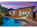 Backyard pool featuring a baja step, mature landscaping, and a covered patio with sliding glass doors at 708 Kibbey St, Las Vegas, NV 89178
