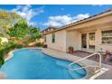 Swimming pool with a baja step and a covered patio that provides shade and outdoor space at 708 Kibbey St, Las Vegas, NV 89178
