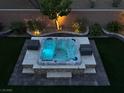 Overhead view of a modern hot tub, lit up at night, surrounded by decorative landscaping at 7424 Rainford St, Las Vegas, NV 89148