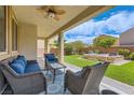Comfortable covered patio with ample seating and views of the lush backyard and hot tub at 7424 Rainford St, Las Vegas, NV 89148