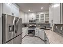 This kitchen features white cabinets, stainless steel appliances, and granite countertops at 75 N Valle Verde Dr # 211, Henderson, NV 89074