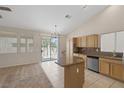 Open kitchen area with a large island, stainless steel appliances, and a sliding door to the patio at 7544 Coral River Dr, Las Vegas, NV 89131
