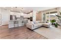 Open-concept living room with a large sectional sofa, open kitchen and sliding glass doors to patio at 8351 Vinamala Ave, Las Vegas, NV 89149
