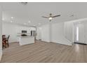 Bright, open-concept living space features modern hardwood floors, recessed lighting, and an attached kitchen with stainless appliances at 8852 Flora Run Ave, Las Vegas, NV 89166