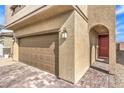 Charming two-story home featuring a brick driveway, two-car garage, arched entry, and low-maintenance landscape at 9114 Riverlands Ranch St, Las Vegas, NV 89139