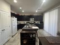 Bright kitchen featuring dark cabinets, granite counters, and a center island at 933 Kimbark Ave, Las Vegas, NV 89148