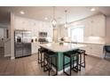 Bright kitchen features a large island with seating, stainless steel appliances, and ample white cabinetry at 9807 Panther Hollow St, Las Vegas, NV 89141