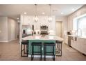 Spacious kitchen boasts an island with barstool seating, stainless steel appliances, and modern lighting at 9807 Panther Hollow St, Las Vegas, NV 89141