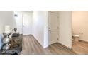 Clean entryway featuring wood-look floors, white walls, and a half bathroom at 1027 Gentle Swan St # 689, Henderson, NV 89011