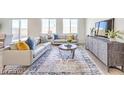 Bright and airy living room with neutral decor, large windows, and stylish furniture at 1027 Gentle Swan St # 689, Henderson, NV 89011