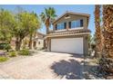 Exterior of a two-story home featuring desert landscaping and a two-car garage at 10902 Pentland Downs St, Las Vegas, NV 89141