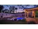 Beautiful backyard with an illuminated pool, covered patio, and serene ambience for evening enjoyment at 1413 Gentle Brook St, North Las Vegas, NV 89084