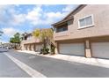 Two-story home exterior showcasing a three-car garage and neighboring units at 2152 Jasper Bluff St # 103, Las Vegas, NV 89117