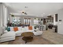 Spacious open-concept living area featuring a large sofa, a kitchen bar and a dining table at 2169 Rio Rancho Pointe Pl, Henderson, NV 89002