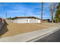 A single-story home showing the front exterior, gravel landscaping, and a quaint neighborhood street view at 2496 Golfers St, Las Vegas, NV 89142
