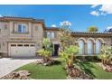Charming two-story home featuring manicured landscaping, a three-car garage, and a welcoming entrance with decorative elements at 2577 Luberon Dr, Henderson, NV 89044