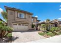 Beautiful home with a paver driveway, three-car garage, manicured lawn, and tasteful architectural details at 2577 Luberon Dr, Henderson, NV 89044