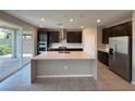 Modern kitchen boasts an island, stainless steel appliances, and sliding door access to the backyard at 2620 Tolmezzo St, Henderson, NV 89044
