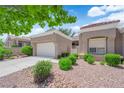 Well-kept home showcasing desert landscaping, a two-car garage, and a tile roof under a sunny blue sky at 2701 Glencliff Dr, Las Vegas, NV 89134
