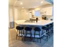 Bright kitchen featuring a quartz countertop island with seating, white cabinets, and stainless steel appliances at 2813 Painted Rose Ln, Henderson, NV 89074
