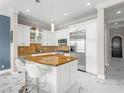Bright kitchen features white cabinetry, stainless steel appliances, a granite island, and sleek marble floors at 30 Via Vasari # 103, Henderson, NV 89011