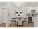 Dining area with a table, stylish chandelier, and adjacent kitchen for convenient meals at 3318 N Decatur Blvd # 1020, Las Vegas, NV 89130