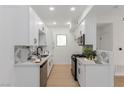 Modern kitchen with white cabinets, stainless steel appliances, and stylish backsplash at 3318 N Decatur Blvd # 1020, Las Vegas, NV 89130