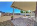 Wide backyard featuring a covered patio area, low maintenance desert landscaping, and privacy fencing at 405 Prairie Moon Ave, North Las Vegas, NV 89084